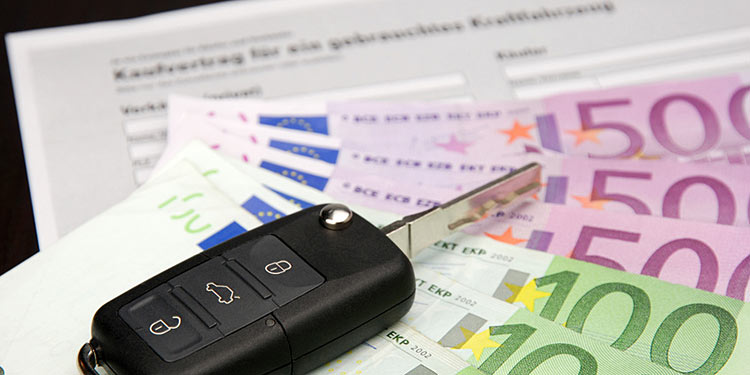 VW-Schlüssel mit Gebrauchtwagen-Kauzfvertrag und Geldscheinen